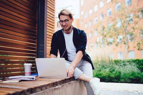 Mai Jos Bărbat Pozitiv Uzură Casual Ochelari Căști Folosind Laptop — Fotografie, imagine de stoc