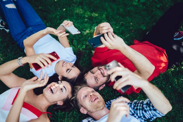 Group Cheerful Hipster Guys Resting Park Grass Using Mobile Gadgets — Stock Photo, Image