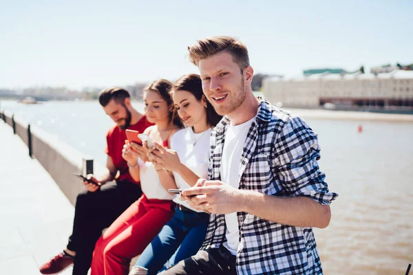 Yakışıklı adamın portresi, bluetooth 'a bağlı senkronize akıllı telefon cihazları ile online oyunlar oynayan beyaz tenli hippi çocuklarla buluşmaktan keyif alıyor.