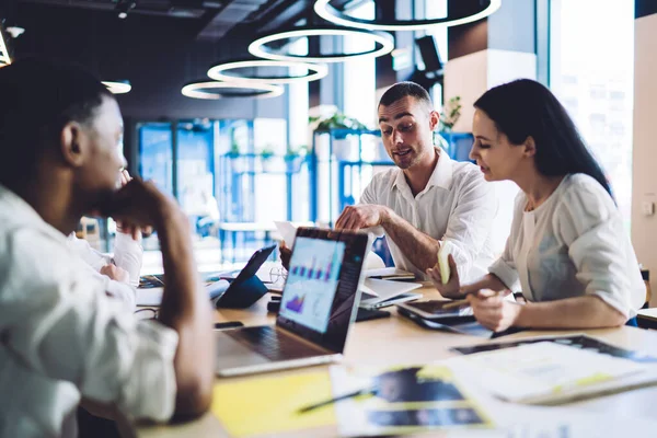 Volwassen Man Gesprek Met Multiraciale Collega Terwijl Aan Tafel Zitten — Stockfoto