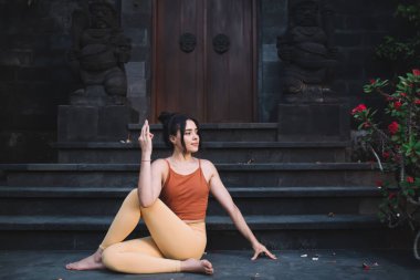 Aktif giyimde sakin çekici bir kadın Asana 'da dinleniyor sağlıklı yaşam tarzını ve sağlığını koruyor spordan ve yoga eğitiminden zevk alan güçlü esnek bir kadın mükemmel vücut yapısını ve canlılığını koruyor.