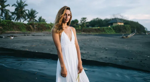 Mulher Macia Vestido Branco Costa Arenosa Perto Mar Ondulando Olhando — Fotografia de Stock