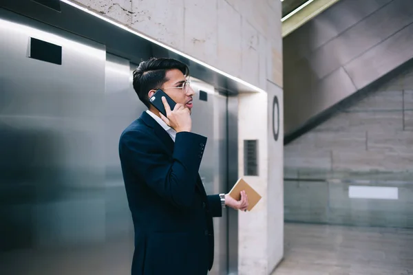 Вид Сбоку Молодого Мужчины Стильном Костюме Очках Разговаривающего Мобильному Телефону — стоковое фото