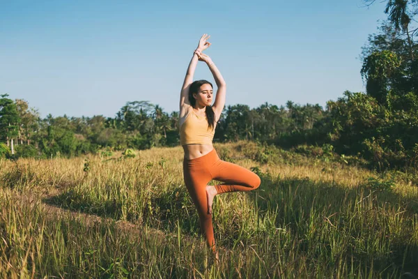 Bella Giovane Donna Etnica Activewear Facendo Tree Pose Con Braccia — Foto Stock