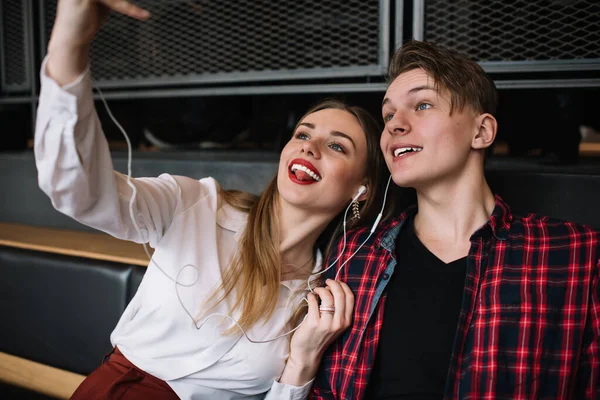 Positief Jong Paar Casual Kleding Oortelefoons Zitten Samen Glimlachen Terwijl — Stockfoto