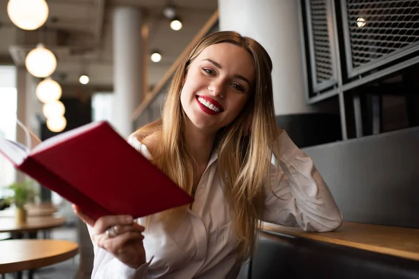 Positive Young Female Red Lips Holding Book While Sitting Sofa — Stock Photo, Image