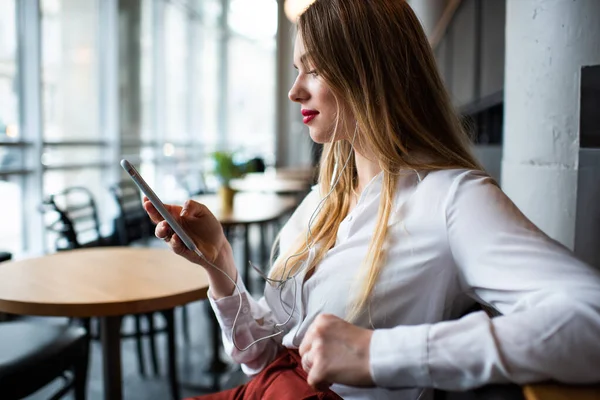 Kafede Otururken Akıllı Telefon Dinlemek Için Müzik Seçen Şık Kıyafetli — Stok fotoğraf