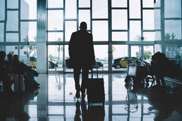 Visão Traseira Macho Irreconhecível Saindo Aeroporto Contemporâneo Levando Mala Enquanto — Fotografia de Stock