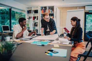 Ortak bir başlangıç projesi geliştirmek için beyin fırtınası toplantısı sırasında masada bir araya gelen yaratıcı etkin erkek ve kadın grubu