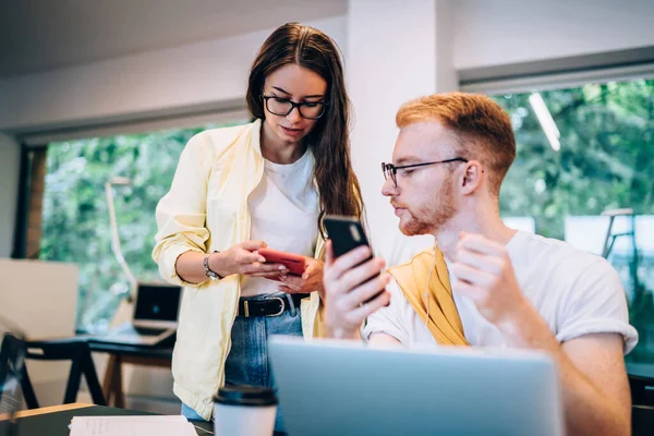 Young Man Listening Music Focusing Screen Smartphone Female Coworker While — Stock Photo, Image