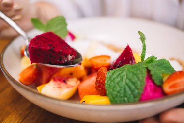 Tabakta taze organik meyve, fırında granola ve naneli sağlıklı bir sabah yemeği, ev yapımı vejetaryen yemeği ve düşük kalorili besin tabağı.