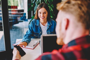 Erkek ve kadın serbest çalışanlar birlikte çalışma alanındaki ortak uzaktan beyin fırtınası sırasında içerik metni aldılar, mutlu Kafkas kullanıcıları çevrimiçi blog yazarken dizüstü bilgisayar ve cep telefonu ile eğlendiler