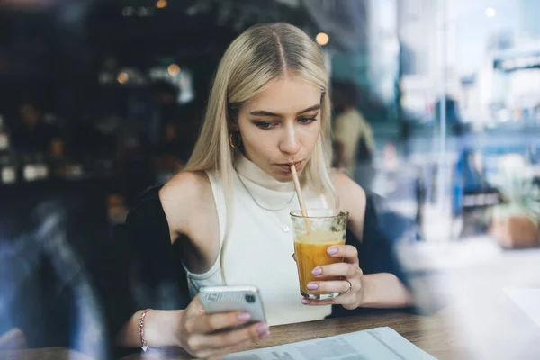 Window View Young Blond Female Drinking Orange Juice Straw Surfing — Stock Photo, Image
