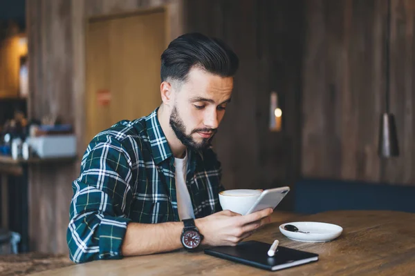 Serious Young Man Beard Mustache Casual Wear Drinking Coffee Surfing — Stock Photo, Image