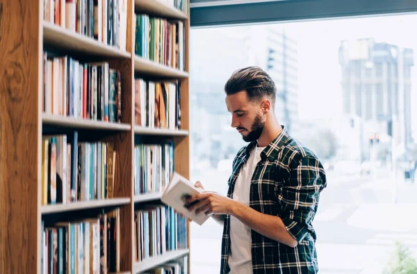 Вид Збоку Бородатого Чоловіка Картатій Сорочці Читаючи Цікаву Книгу Стоячи — стокове фото