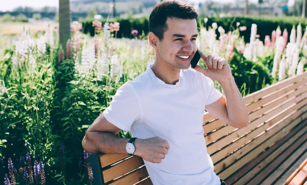 Cheerful Young Male Speaking Mobile Phone Resting Green Bench Park — Stock Photo, Image