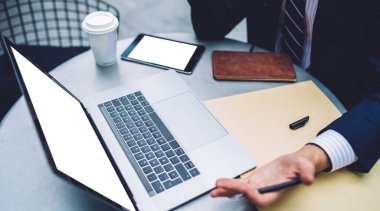 Ekin akıllı işadamı dizüstü bilgisayar ve çalışma masasında tablet üzerinde çalışırken elinde kalemle el kol hareketi yapıyor.