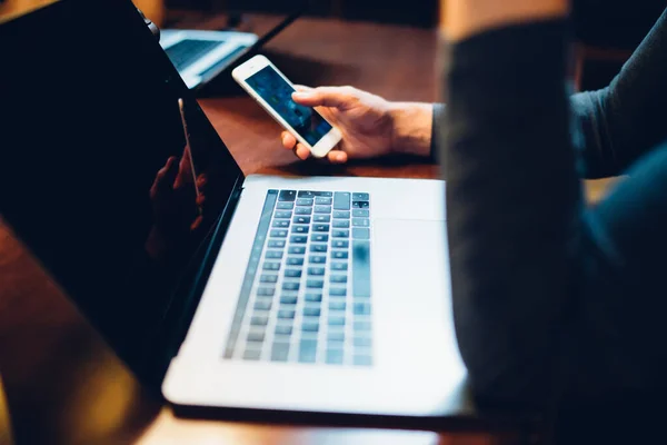 Crop Person Browsing Mobile Phone Sitting Open Laptop Table Warm — Stock Photo, Image