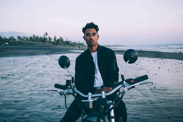 Kaygısız Genç Erkek Motorcu Siyah Motosiklet Üzerinde Oturuyor Kumsalda Kameraya — Stok fotoğraf