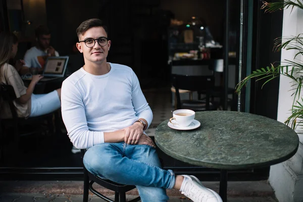 Feliz Jovem Casualmente Vestido Homem Com Óculos Pernas Cruzadas Descansando — Fotografia de Stock