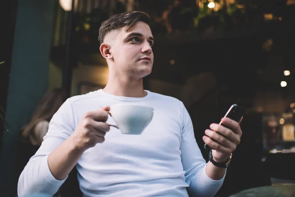 Freelancer Masculino Pensativo Ropa Casual Sosteniendo Una Taza Café Navegando —  Fotos de Stock