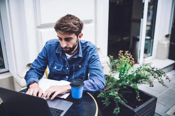 Concentrado Jovem Macho Camisa Jeans Usando Laptop Para Trabalho Enquanto — Fotografia de Stock