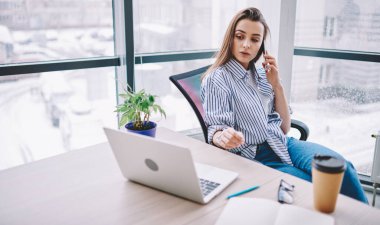 Ciddi bir kadın, modern akıllı telefon ve netbook teknolojisinde 4G ofis interneti kullanarak Webinar hakkında konuştuğu için uzaktan meslektaşını arıyor.