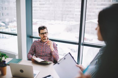 Optik gözlüklü Kafkas işvereni, kesilen stajyerin göz düzeltme bilgilerini sağlaması için ofis içi görüşme sırasında erkek ve kadın iletişimi