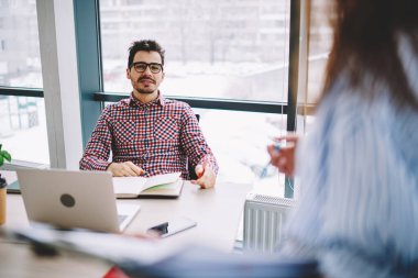 Optik gözlüklü Kafkas işvereni, kesilen stajyerin göz düzeltme bilgilerini sağlaması için ofis içi görüşme sırasında erkek ve kadın iletişimi
