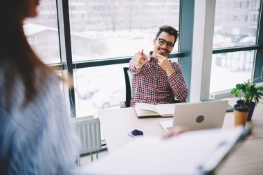 Modern ofis çalışma alanındaki işe alım anketi sırasında optik göz giyiminde başarılı olan ve iş görüşmesi sırasında komik fikirleri tartışan başarılı bir adam.