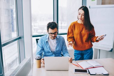 Akıllı gündelik kıyafet giyen genç erkek ve kadın çalışanlar modern iş yerinde uzaktan işbirliği sırasında web projeksiyonunu tartışıyor, Kafkasyalı bilişim uzmanları bankacılık uygulaması üzerinde beyin fırtınası yapıyor