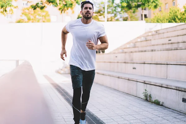 在城市街道上 强壮的白人男性穿着运动服慢跑 戴耳机的运动员一边听音乐 一边进行有氧训练 以保持健康的生活方式和完美的体形 — 图库照片