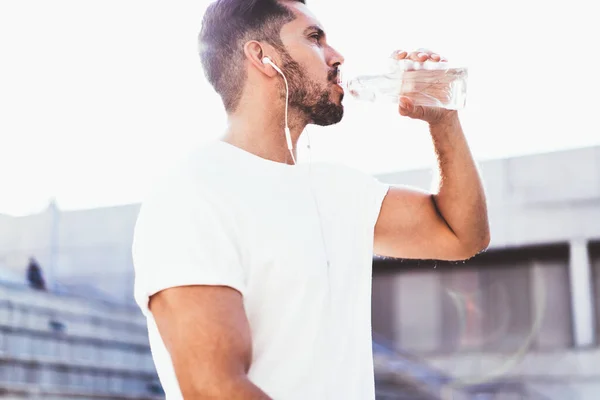 Красивый Мужчина Лет Питьевой Воды После Кардио Бега Тренировки Слушать — стоковое фото