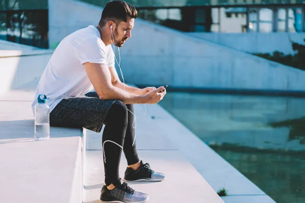 Entrenador Muscular Del Cuerpo Usando Auriculares Electrónicos Para Ver Video — Foto de Stock