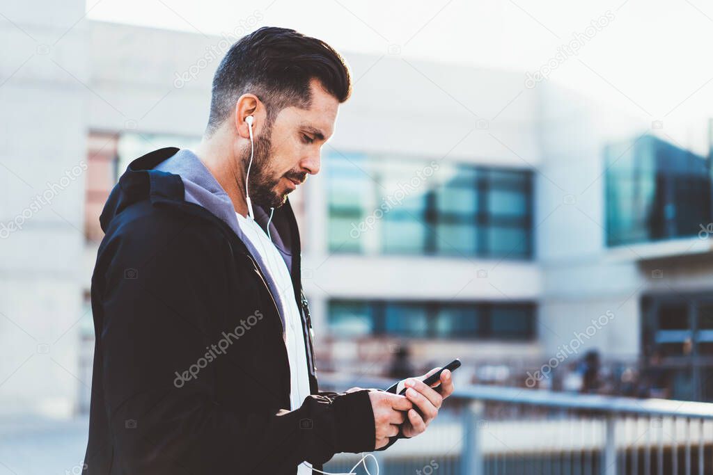 Muscular runner have workout break for text messaging with social followers from web blog about healthy lifestyle, good looking man using 4g wireless on cellphone for search online training