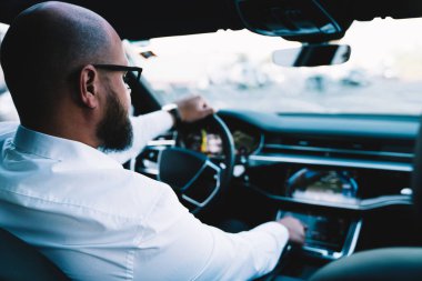 Çağdaş otomobilin otomatik pilotu için otomatik pilotu seçen iş adamı, rahat iç mekânlı, seyir sensörünü otomatik olarak kontrol eden erkek sürücü.