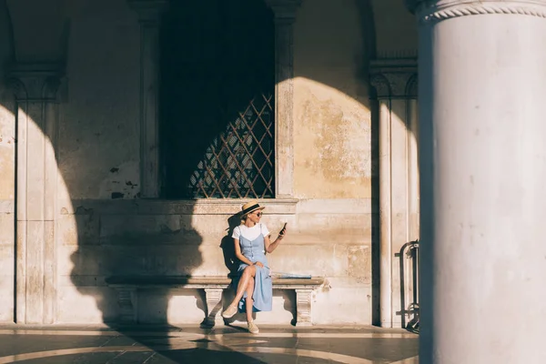 Veselá Mladá Žena Klobouku Drží Dívá Mobilní Telefon Zatímco Odpočívá — Stock fotografie