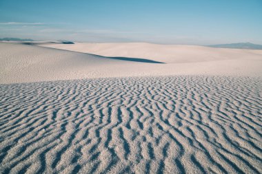 Beyaz Kumlar Ulusal Parkı 'ndaki kumlu kum tepelerinin yüksek açısı güneşli bir günde mavi bulutlu gökyüzüne karşı.