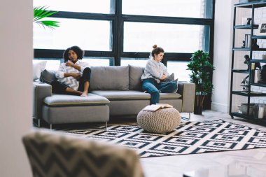 Bir sürü mutsuz kadın büyük pencerelere karşı ayrı ayrı kanepede oturuyor ve birbirleriyle konuşmuyorlar.