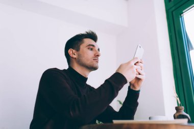 Kafkasyalı bin yıllık bir adam cep telefonu bağlantısı kullanarak mesaj göndermek için mesaj yazıyor, genç bir erkek blogcu akıllı telefon uygulaması ile sosyal ağ güncellemesi sırasında profilini kontrol ediyor