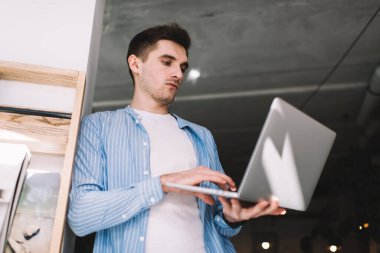 Teknoloji uygulamasını geliştirirken modern dizüstü bilgisayardaki güncellemeleri kontrol eden yetenekli beyaz programcı, milenyum erkeği internet bankacılığı yaparken iş dünyasının internet sitesinden bilet alıyor