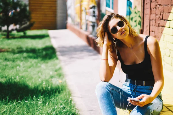 Junge Frau Lässiger Kleidung Und Sonnenbrille Sitzt Auf Dem Boden — Stockfoto