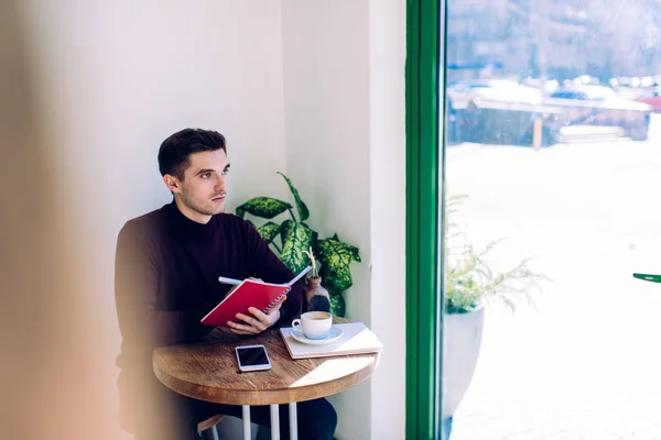 Pensive Hipster Guy Holding Education Textbook Creating Project Ideas Coffee — Zdjęcie stockowe