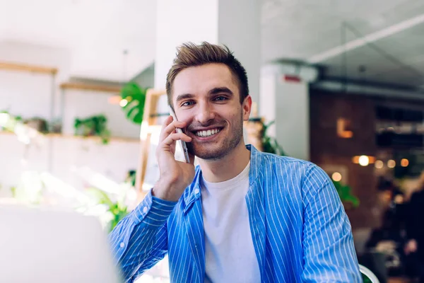 Half length of cheerful Caucasian man making positive cellular conversation for discussing contact details, portrait of happy male millennial enjoying phoning call via smartphone application