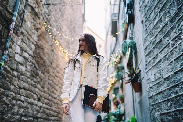 站在巴塞罗那市狭窄的街道上 一个面带微笑 面目全非的年轻漂亮女子的低角度 — 图库照片