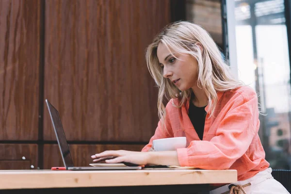 Jovem Freelancer Feminino Concentrado Roupa Casual Usando Laptop Beber Café — Fotografia de Stock