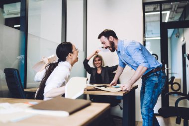 İlk kez resmi kıyafet giyen girişimciler ofiste beyin fırtınası yaptıktan sonra dokümanları çeviriyor ve kollarını kaldırıyorlar.
