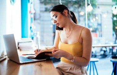 Klasik gözlüklü beyaz bir kız iş arkadaşını arayıp iş görüşmesi için 4G internete bağlanıyor, cep telefonu teknolojisi kullanarak internet üzerinden çalışan yetenekli bir kadın serbest yazar.