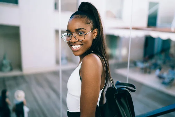 Щаслива Молода Афроамериканська Жінка Повсякденному Одязі Окулярах Рюкзаком Хвостиком Стоять — стокове фото