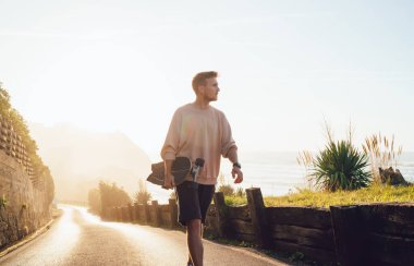 Tanımlanamayan bir adam, uzun pano elinde, uzun bir günün ardından setin üzerinde yürüyor ve gözlerini kaçırıyor.